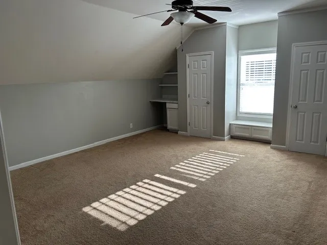 a view of empty room with fireplace and fan