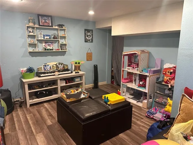 a living room with furniture and a baby crib