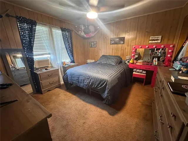 a bedroom with a bed window and dresser