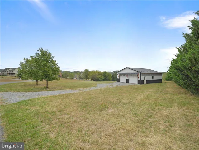 a view of a house with a yard and a large tree