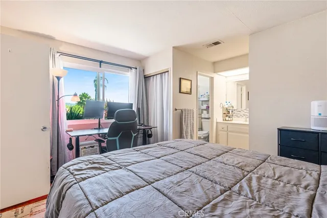 a bedroom with a bed table and chair