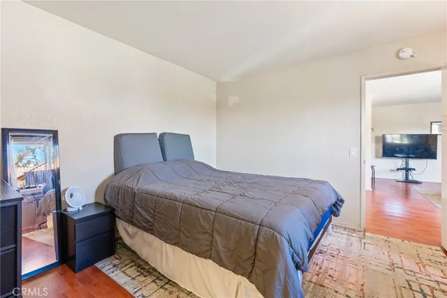 a bedroom with a bed and wooden floor