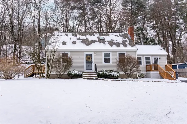 a front view of a house with a yard covered in snow