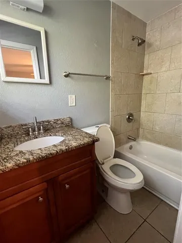 a bathroom with a granite countertop toilet a sink and bathtub