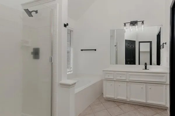 a spacious bathroom with a bathtub sink and mirror