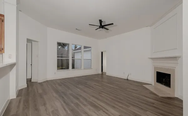 a view of empty room with wooden floor and fireplace