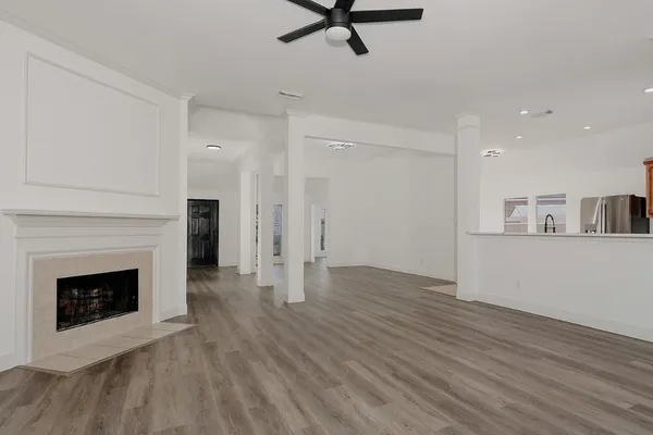 a view of a livingroom with wooden floor and a fireplace