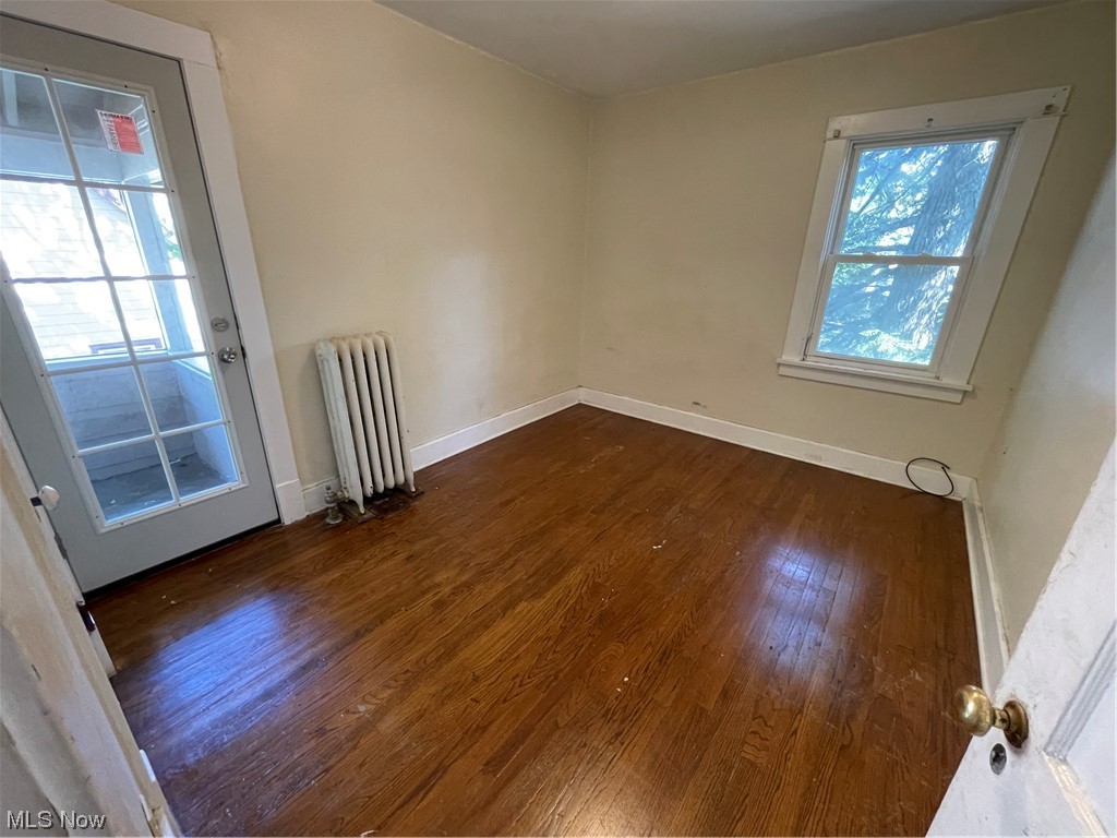 1730 Wood Road Cleveland Heights, OH 44121 - Photo 26 of 34 Hardwood floored empty room with radiator heating unit