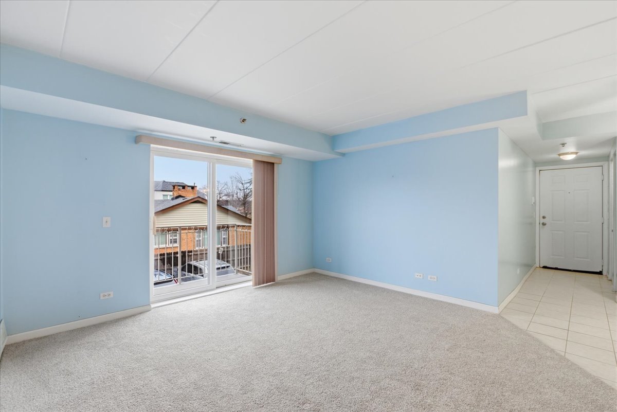 7316 40th Street, Unit 2E Lyons, IL 60534 - Photo 5 of 14 an empty room with a fireplace and a window