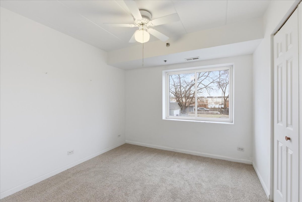 7316 40th Street, Unit 2E Lyons, IL 60534 - Photo 9 of 14 an empty room with a window and a fan
