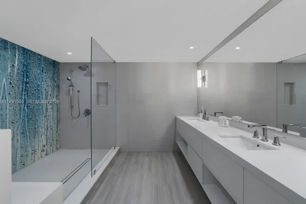a bathroom with a double vanity sink mirror and shower