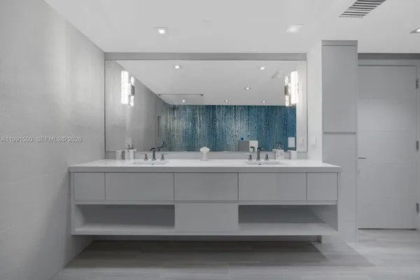 a bathroom with double vanity sink and a mirror