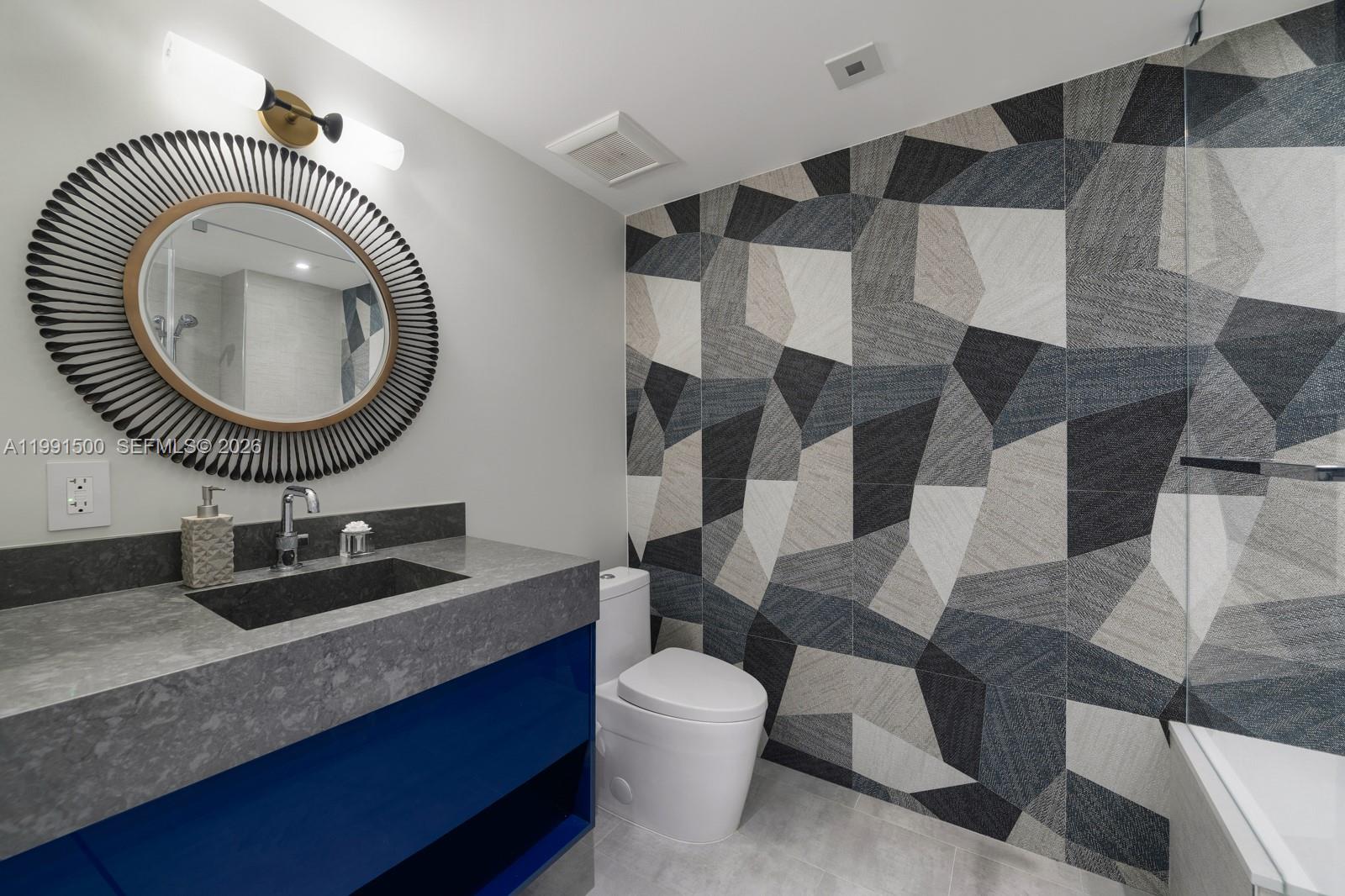 9559 Collins Avenue, Unit S8B Surfside, FL 33154 - Photo 17 of 42 a bathroom with a toilet a sink and a mirror