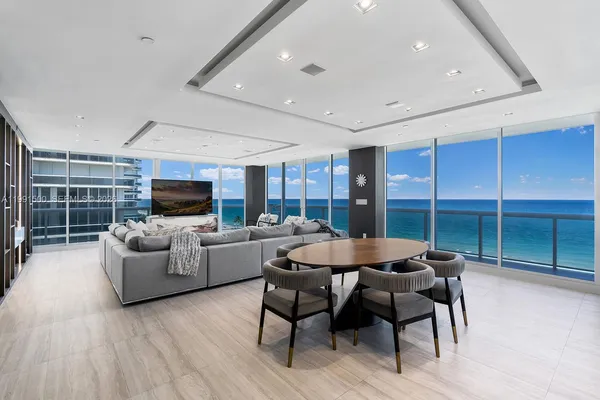 a living room with furniture a flat screen tv and a large window