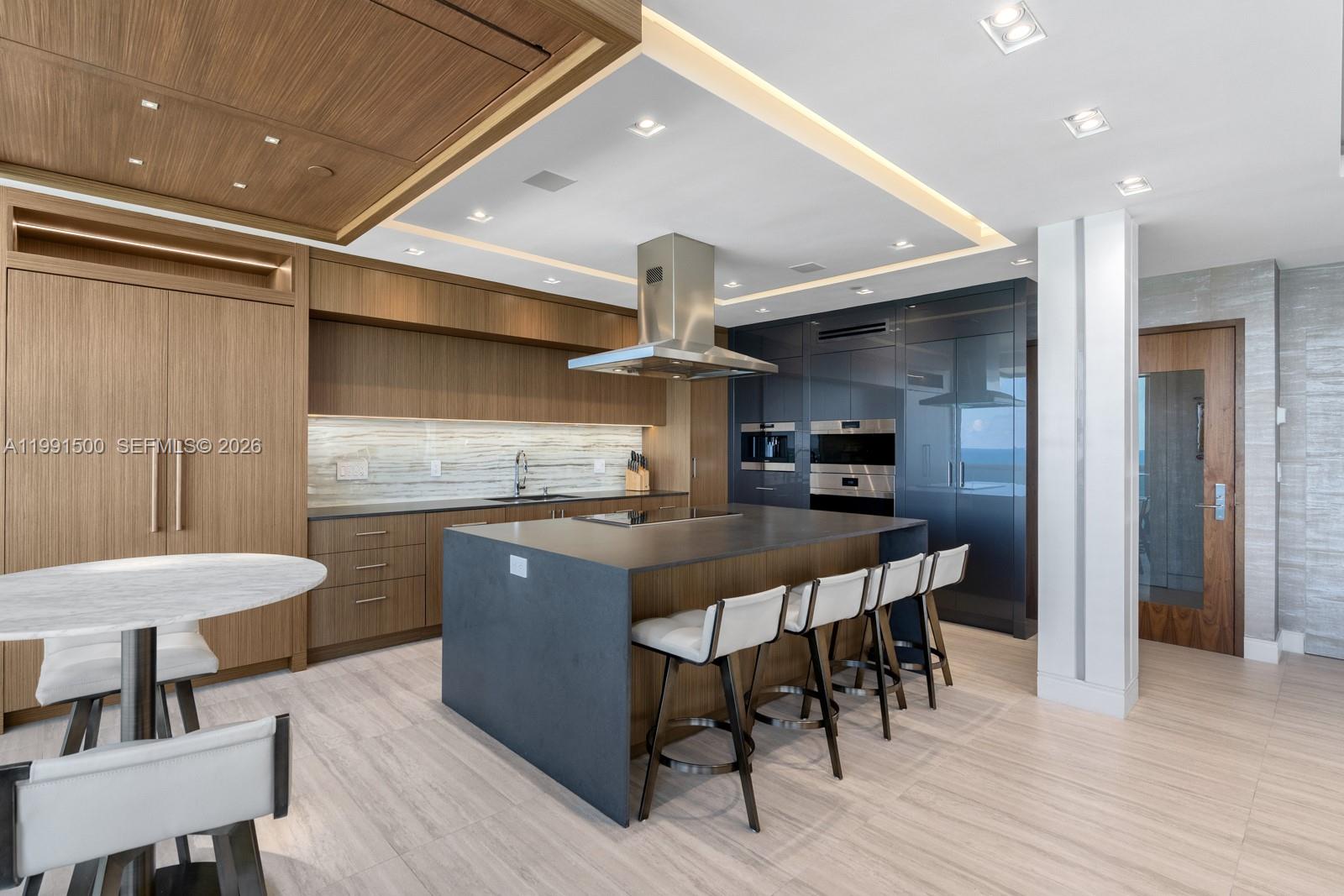 9559 Collins Avenue, Unit S8B Surfside, FL 33154 - Photo 31 of 42 a kitchen with stainless steel appliances a dining table chairs and wooden floor