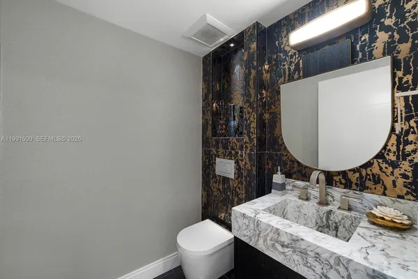 a bathroom with a sink toilet and mirror