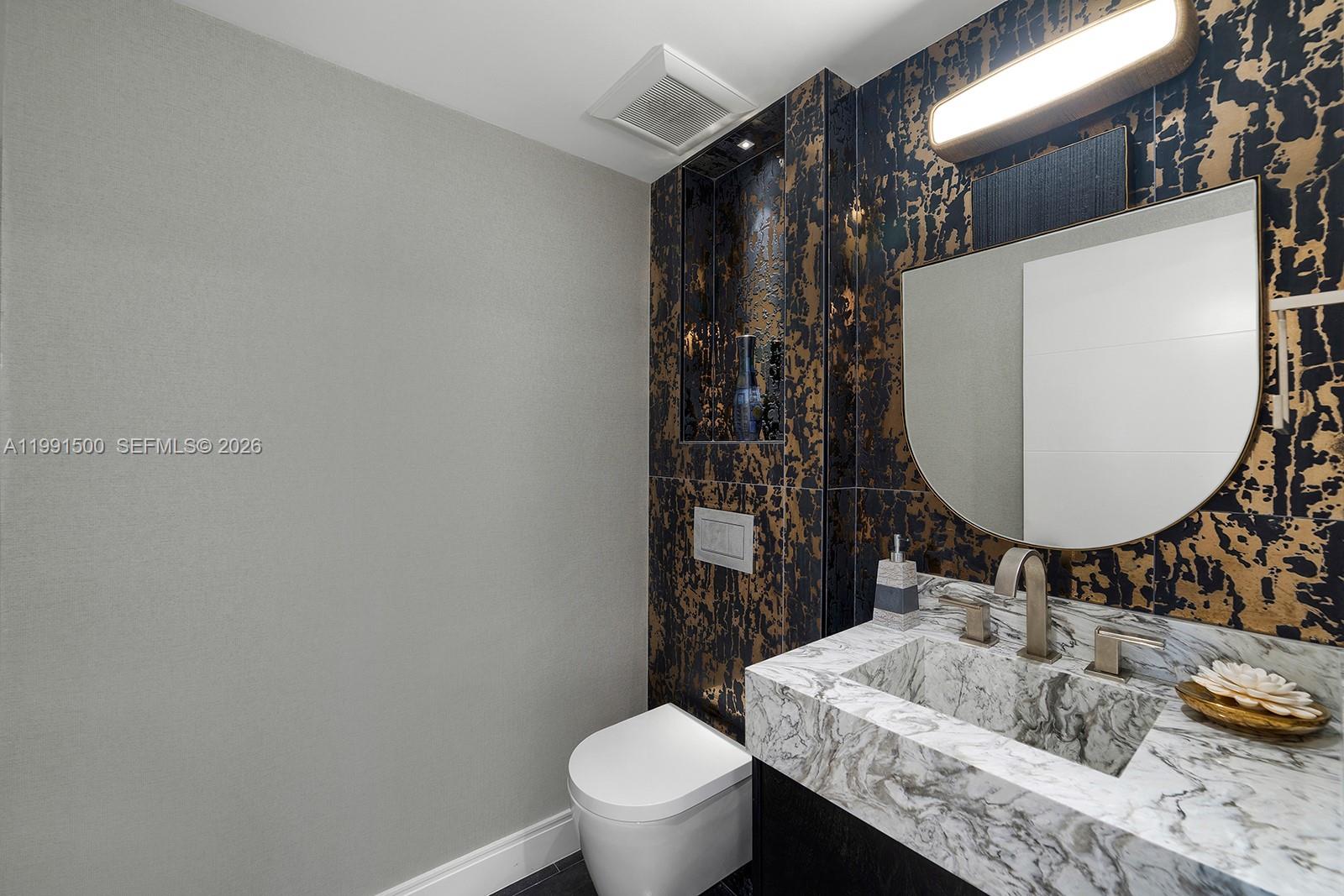 9559 Collins Avenue, Unit S8B Surfside, FL 33154 - Photo 32 of 42 a bathroom with a sink toilet and mirror