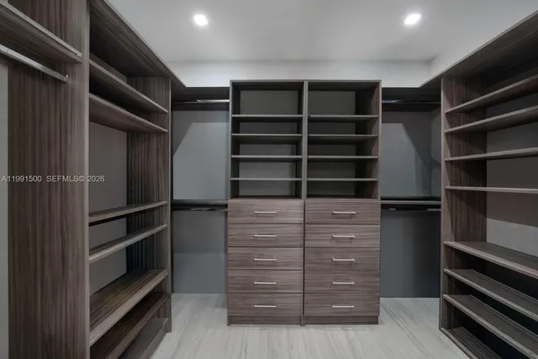 a view of walk in closet with empty racks