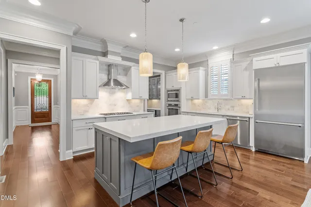 a kitchen with granite countertop a table chairs refrigerator and microwave