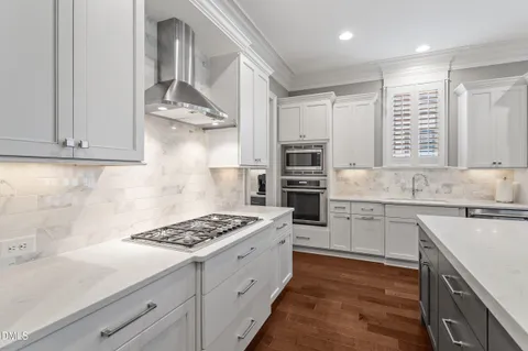 a kitchen with stainless steel appliances a sink stove and cabinets
