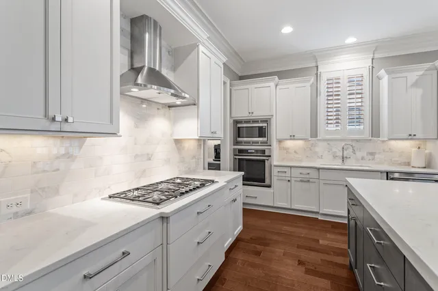 a kitchen with stainless steel appliances a sink stove and cabinets