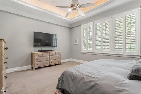 a bedroom with a bed and a flat tv screen on dresser