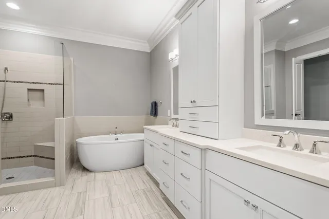 a spacious bathroom with a double vanity sink mirror and bathtub