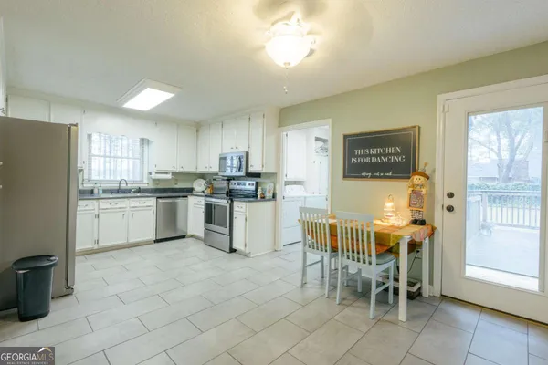 a kitchen with cabinets and chairs