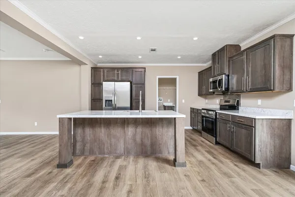 a kitchen with stainless steel appliances granite countertop a stove a sink and a refrigerator