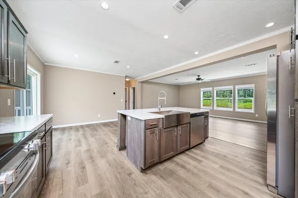 a large kitchen with a large counter top and wooden floors
