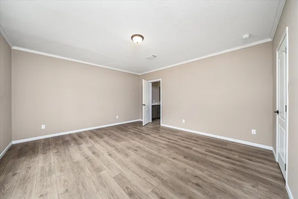 a view of an empty room with wooden floor