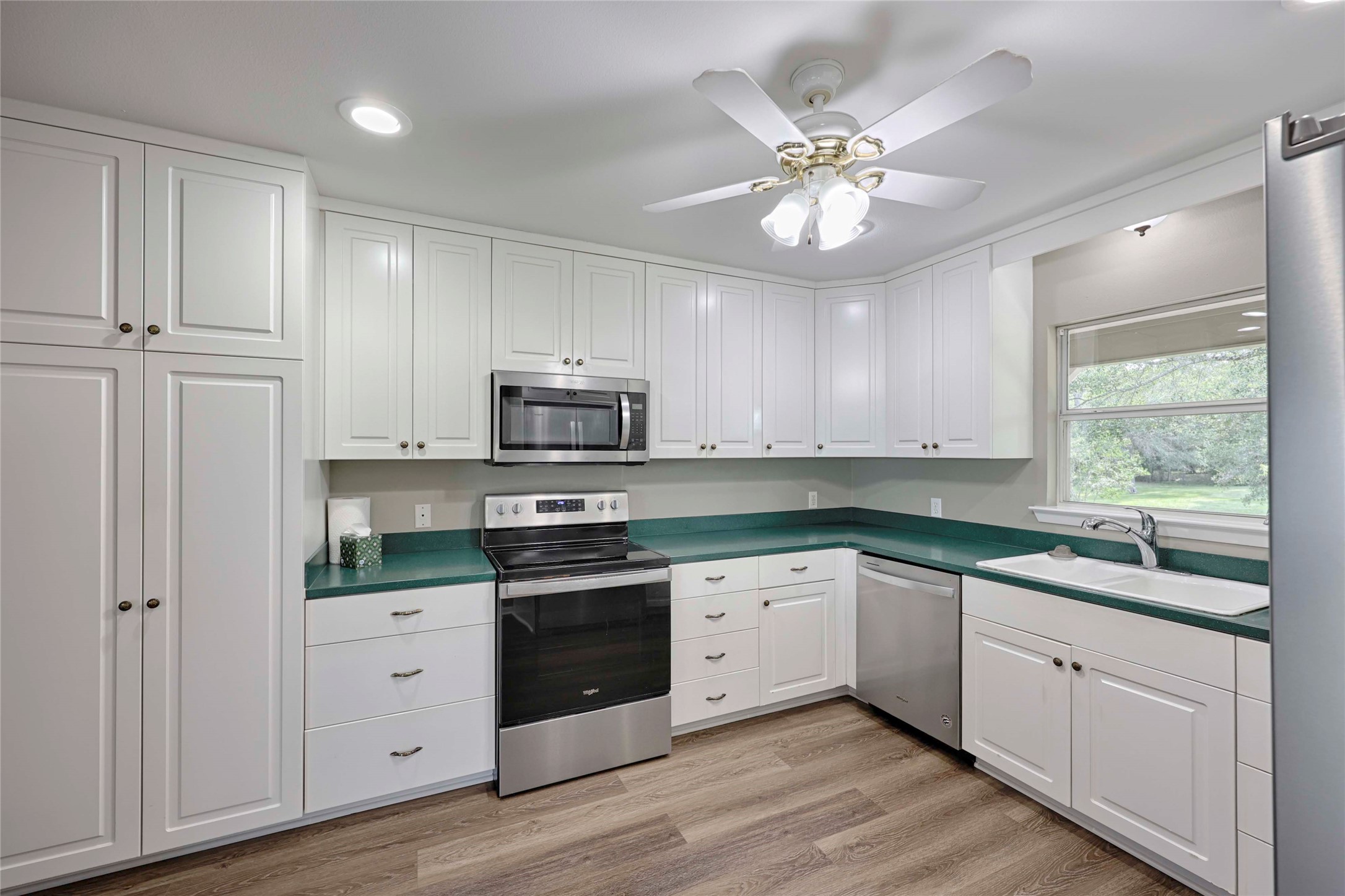 3545 East I- 10 Frontage Road Schulenburg, TX 78956 - Photo 14 of 40 a kitchen with stainless steel appliances granite countertop white cabinets sink and dishwasher with wooden floor