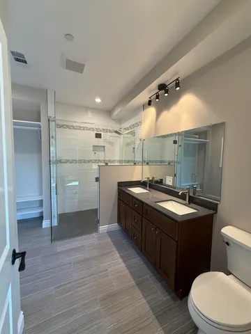 a bathroom with a sink a toilet and mirror