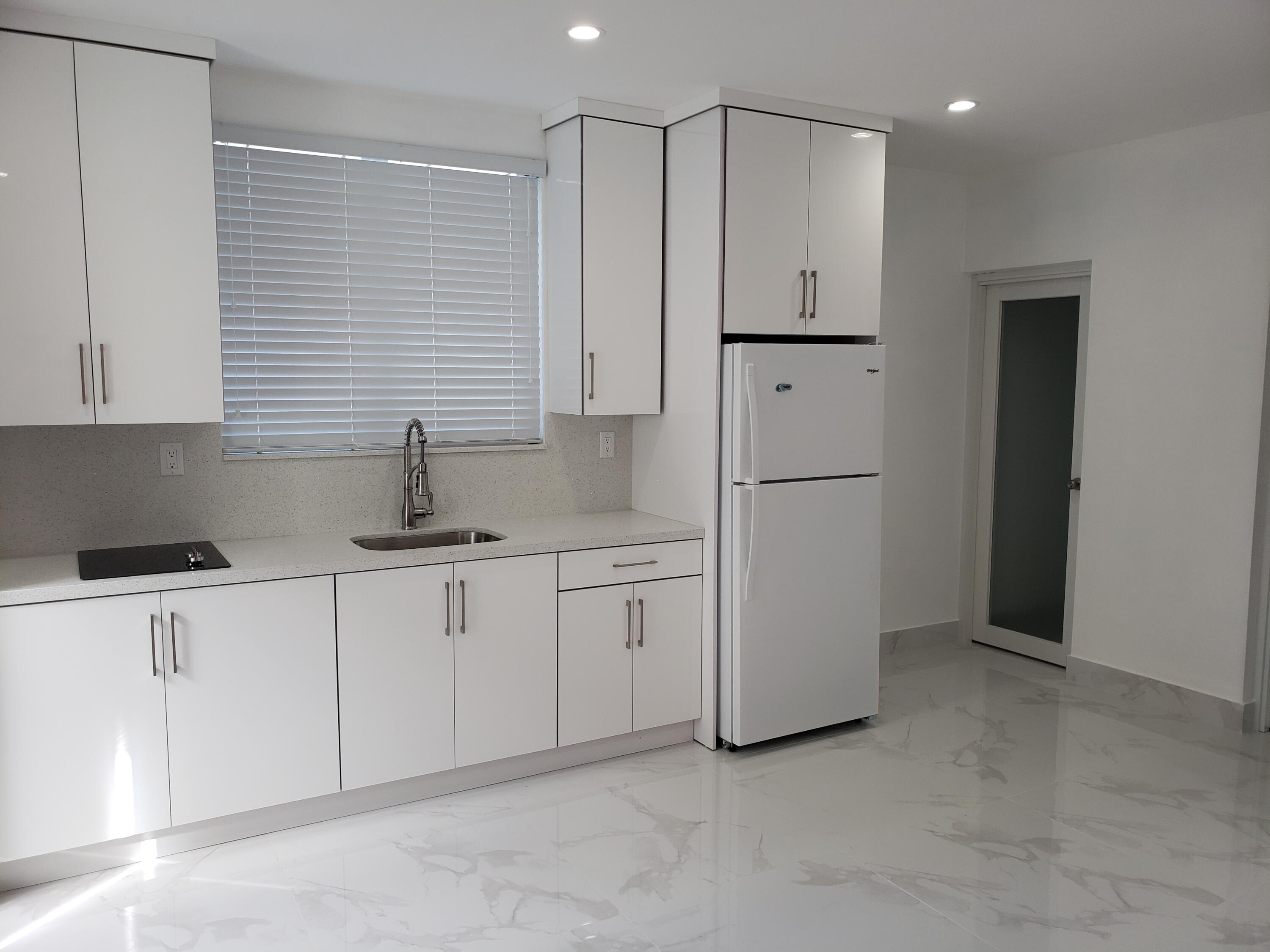 169 Corrine Place Key Largo, FL 33037 - Photo 2 of 6 a kitchen with white cabinets and white refrigerator