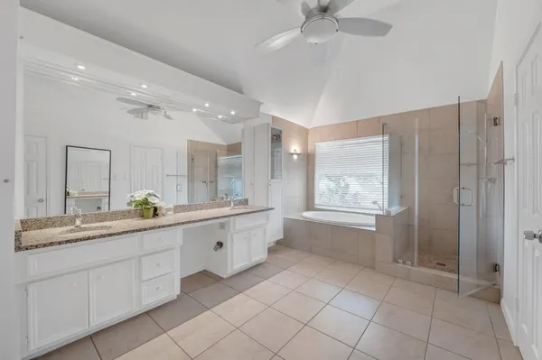 a bathroom with a granite countertop sink mirror and a bathtub