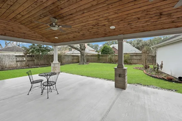 a view of a patio with a table chairs and a backyard