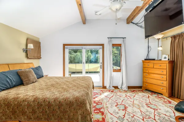 a bedroom with a bed and dresser with mirror