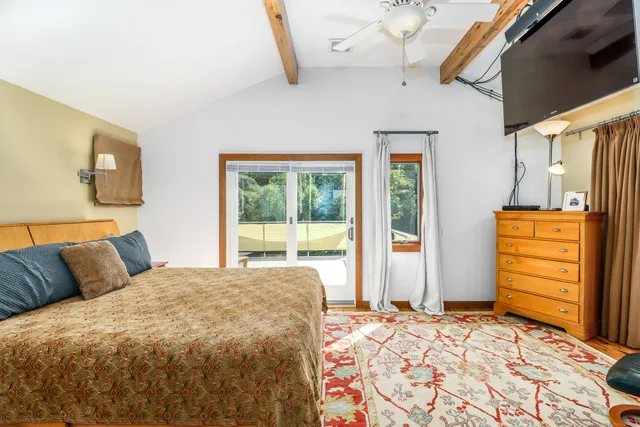 a bedroom with a bed and dresser with mirror