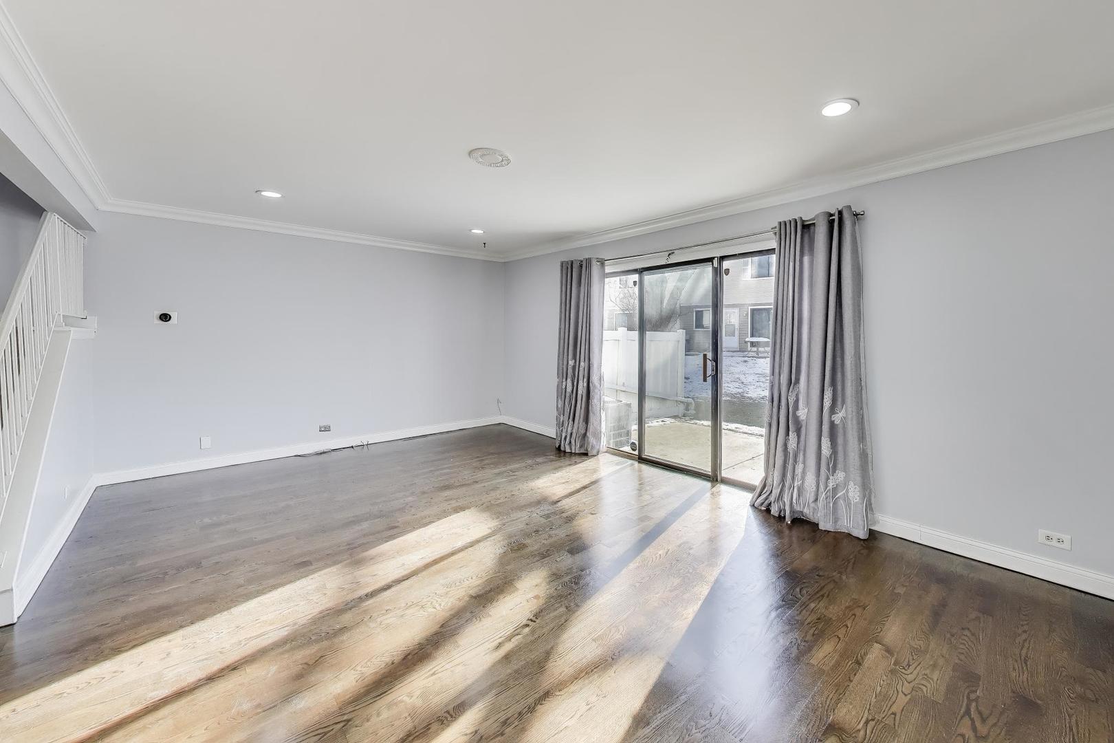 637 Bridgeview Point Schaumburg, IL 60194 - Photo 7 of 28 a view of an empty room with wooden floor and a window