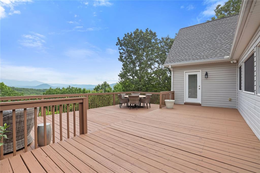 1168 Highland Road Sautee Nacoochee, GA 30571 - Photo 47 of 65 a roof deck with table and chairs a barbeque with wooden floor and fence