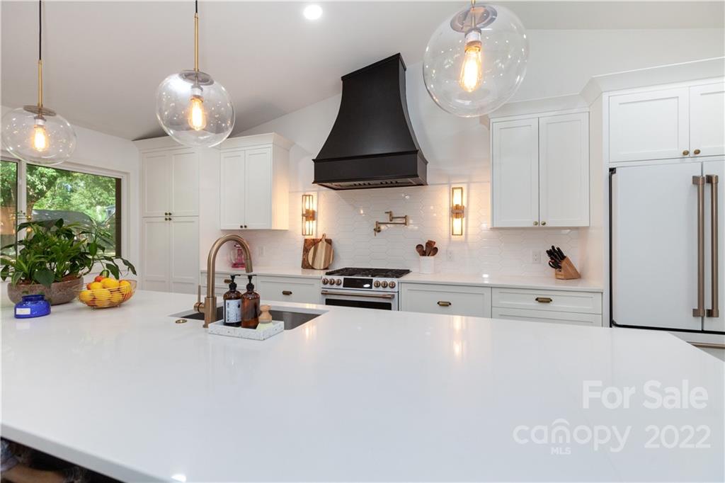 621 Wingrave Drive Charlotte, NC 28270 - Photo 21 of 48 a kitchen with stainless steel appliances a stove a refrigerator and a dining table with the chandelier