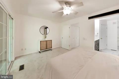 a view of a room with wooden floor and ceiling fan