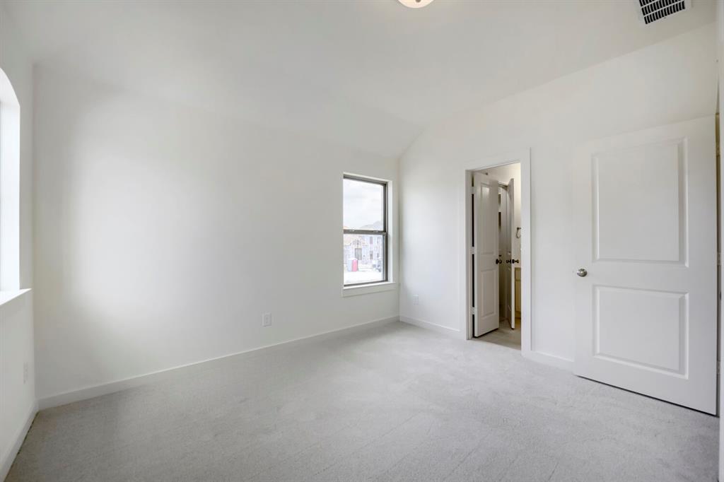 11548 Wulstone Road Haslet, TX 76052 - Photo 18 of 26 Carpeted room featuring a vaulted ceiling and two windows