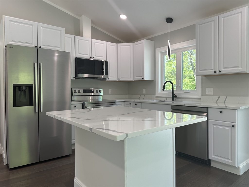 102 Wells Road Becket, MA 01223 - Photo 14 of 40 a kitchen with stainless steel appliances granite countertop a sink a stove a refrigerator a center island and a window