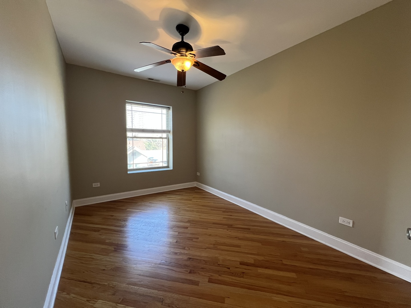 911 Maple Avenue, Unit 3N Evanston, IL 60202 - Photo 5 of 18 a view of an empty room with wooden floor and a window