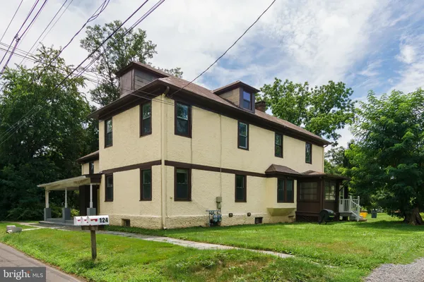 a front view of a house with a yard and trees