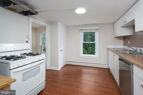 a kitchen with a stove a sink and a window
