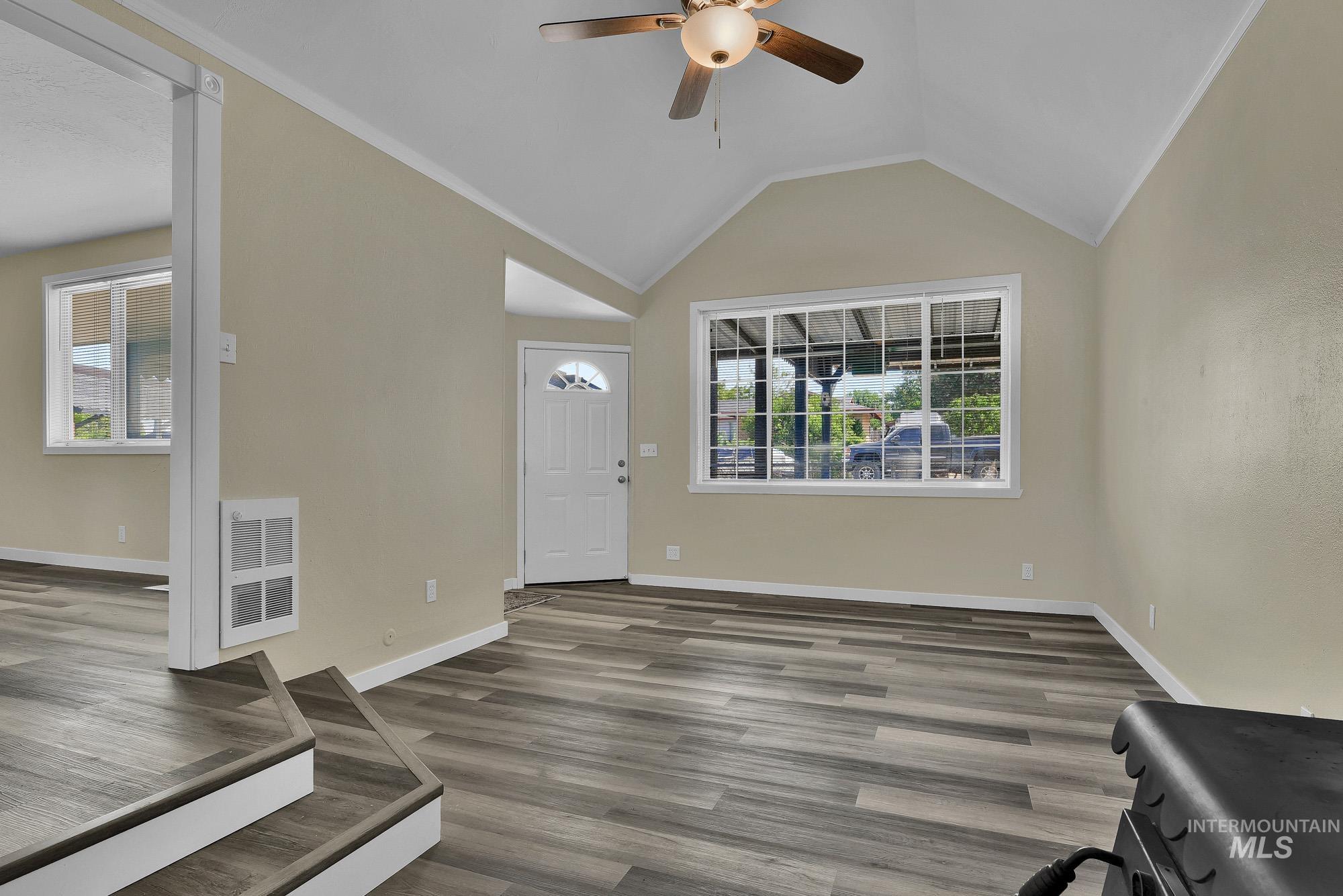 5755 Chuckwagon Road Nampa, ID 83686 - Photo 7 of 50 Vaulted ceiling, wood-finish flooring, white trim, ceiling fan with light, and a white front entry door with an arched window