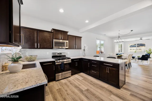 a kitchen with stainless steel appliances granite countertop a sink stove and wooden cabinets