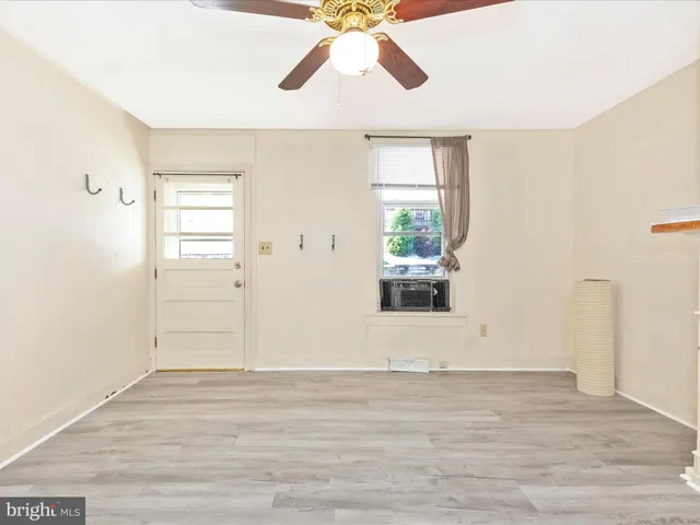 a view of a livingroom with wooden floor and a ceiling fan